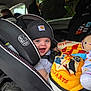 baby, car_seat, beanie, blanket, toy, smiling, child, car_interior, blue_eyes, happy, clothing, seatbelt, infant, cute, warm, hats, portrait, indoors, young_child, cozy