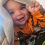 Malakai is registered to the contest to win money with this photo: toddler, child, smiling, blanket, orange_clothing, face, happy, baby, cute, indoor, hand, eyes, portrait, cozy, fabric, comfort, playful, closeup, expression, young