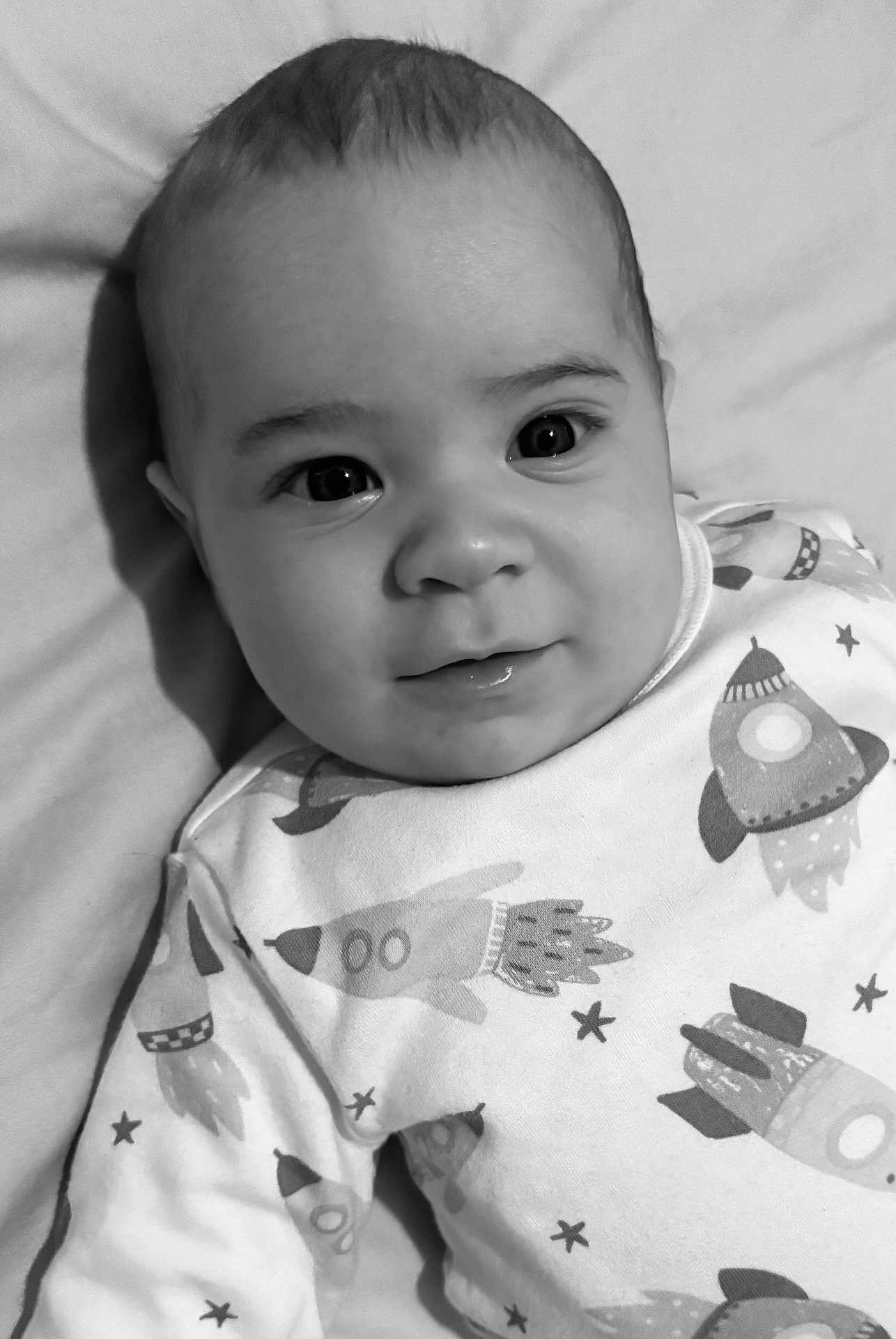Charlie participe au concours pour gagner de l'argent avec cette photo : baby, infant, child, face, eyes, smile, onesie, rocket, stars, blanket, portrait, closeup, monochrome, black_and_white, lying_down, soft_texture, drool, cheeks, gaze, cute