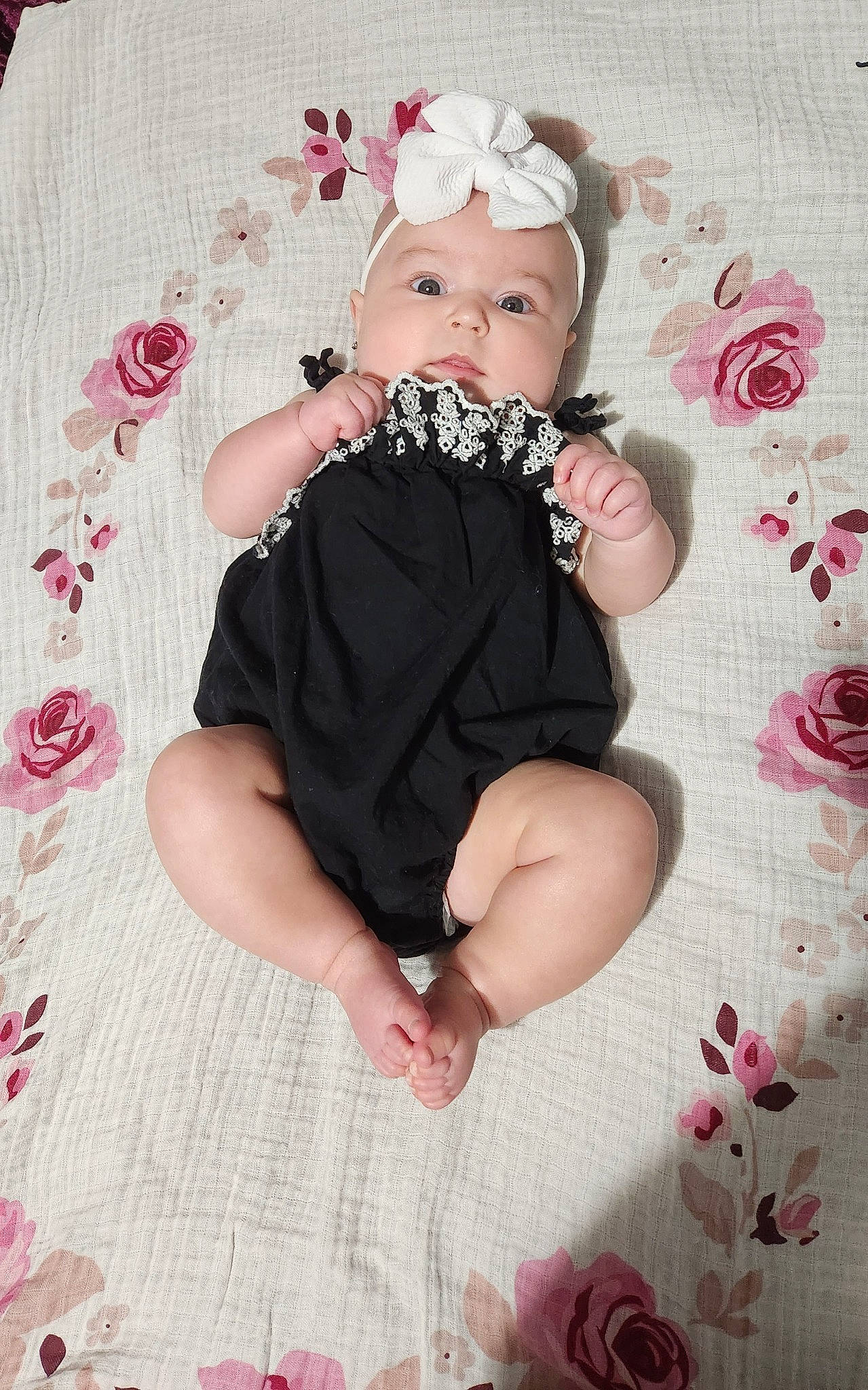 Bailey is registered to the contest to win money with this photo: arm, baby, baby_toddler_clothing, comfort, dress, face, finger, hand, headwear, leg, magenta, pattern, person, petal, pink, purple, skin, sleeve, sock, textile
