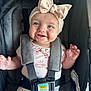 baby, child, smile, blue_eyes, headband, bow, stroller, car_seat, straps, clothing, happy, infant, cute, person, portrait, sitting, indoors, close_up, baby_girl, secure