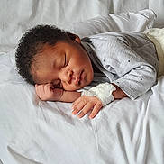 Andy Thomas a rejoint le concours — aidez-le/la à gagner de superbes lots ! baby, sleeping, infant, curly_hair, hospital_bandage, grey_clothing, white_bed, peaceful, resting, child, portrait, soft_light, indoors, closeup, newborn, hand, face, cute, cozy, blanket