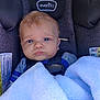 baby, blue_eyes, blanket, car_seat, child, clothing, face, infant, person, portrait, seatbelt, soft_texture, close_up, indoor, cute, young_child, expression, head, baby_boy, security