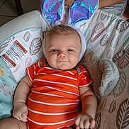 Theo is registered to the contest to win money with this photo: baby, bunny_ears, orange_onesie, smile, infant, cute, plush, cushion, patterned, child, indoor, happy, cheeks, person, toddler, soft_toys, baby_girl, baby_boy, funny_costume, relaxed