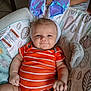 baby, bunny_ears, orange_onesie, smile, infant, cute, plush, cushion, patterned, child, indoor, happy, cheeks, person, toddler, soft_toys, baby_girl, baby_boy, funny_costume, relaxed