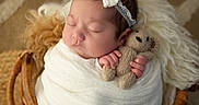 Anaë a rejoint le concours — aidez-le/la à gagner de superbes lots ! newborn, baby, infant, sleeping, wrapped, basket, teddy_bear, headband, bow, blanket, cozy, soft, cute, adorable, peaceful, indoors, portrait, child, woven, texture