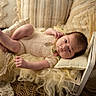 Anaë participe au concours pour gagner de l'argent avec cette photo : baby, infant, bed, blanket, pillow, soft_texture, knitted_clothing, wooden_bed, lying_down, indoors, portrait, curious_expression, cozy, warm_colors, closeup, newborn, resting, cushion, fabric, sleeping_area