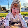 Jace is registered to the contest to win money with this photo: baby, infant, hat, knitted_hat, bear_patch, blanket, outdoor, grass, sunlight, daylight, child, cute, face, hands, clothing, nature, house, sky, tree, portrait