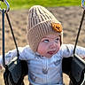 Jace is registered to the contest to win money with this photo: baby, child, swing, hat, knit_hat, bear_patch, playground, outdoor, tongue_out, cute, infant, seat, happy, expression, sunlight, clothing, fun, play, person, young