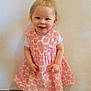 toddler, child, smiling, standing, dress, pink, pattern, sandals, footwear, indoor, wall, floor, happy, person, cute, short_hair, skin, small_person, baby, portrait