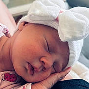 Hilona participe au concours pour gagner de l'argent avec cette photo : baby, sleeping, hat, bow, hand, face, newborn, infant, soft_light, cute, peaceful, pink_clothing, closeup, portrait, cozy, resting, skin, indoor, child, tiny