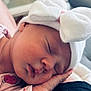 baby, sleeping, hat, bow, hand, face, newborn, infant, soft_light, cute, peaceful, pink_clothing, closeup, portrait, cozy, resting, skin, indoor, child, tiny