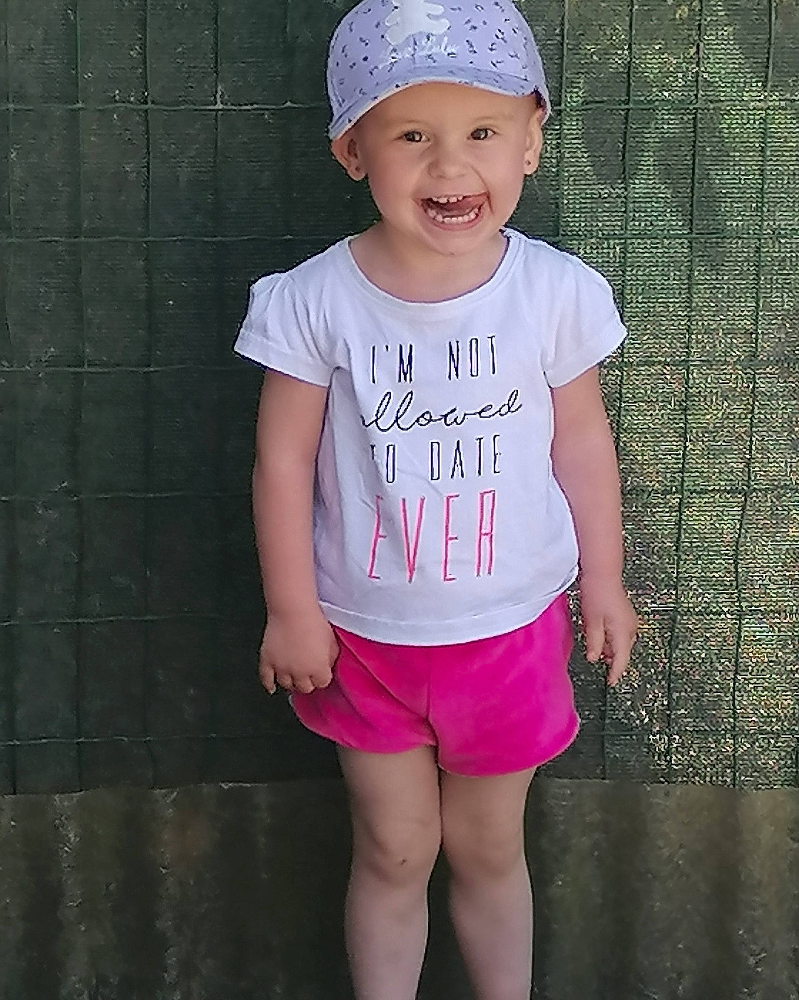 Giulia participe au concours pour gagner de l'argent avec cette photo : active_tank, baby_toddler_clothing, cap, chin, clothing, cool, eye, happy, head, headwear, joy, knee, magenta, neck, person, pink, shoulder, sleeve, smile, t_shirt