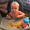 Bowen is registered to the contest to win money with this photo: baby, child, high_chair, spaghetti, messy_eating, sippy_cup, tray, indoor, home, dining, food, noodles, smiling, blue_eyes, blond_hair, sitting, portrait, furniture, family_room, mealtime