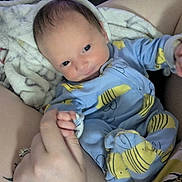 Aurora joined the competition — help win amazing prizes! baby, infant, child, portrait, lying_down, blue_outfit, yellow_pattern, blanket, cozy, indoor, home, adult_arms, caregiver, wide_eyes, looking_at_camera, face, hands, clothing, soft_blanket, family