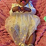 Victoria is registered to the contest to win money with this photo: baby, infant, child, smiling, laughing, tongue_out, headband, bow, dress, sparkly, cream_clothing, pink_blanket, bed, lying_down, portrait, indoor, fashion, sandals, happy, close_up