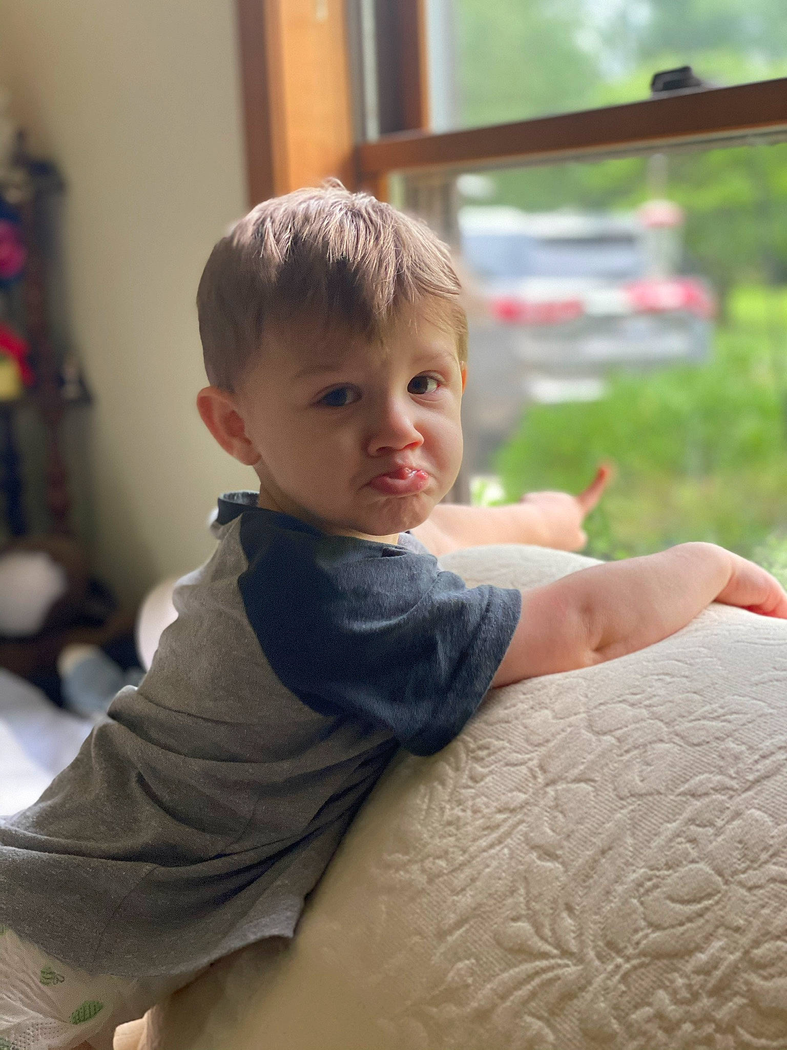 Slayde is registered to the contest to win money with this photo: arm, baby_toddler_clothing, child, comfort, elbow, face, flooring, fun, grass, happy, head, joint, person, sitting, skin, sleeve, standing, t_shirt, toddler, window