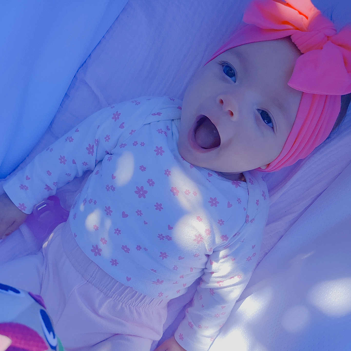 Marly participe au concours pour gagner de l'argent avec cette photo : baby, blanket, bow, child, closeup, clothing, cute, happy, headband, indoors, infant, long_sleeve, lying_down, patterned, person, pink, portrait, smiling, soft_light, toy