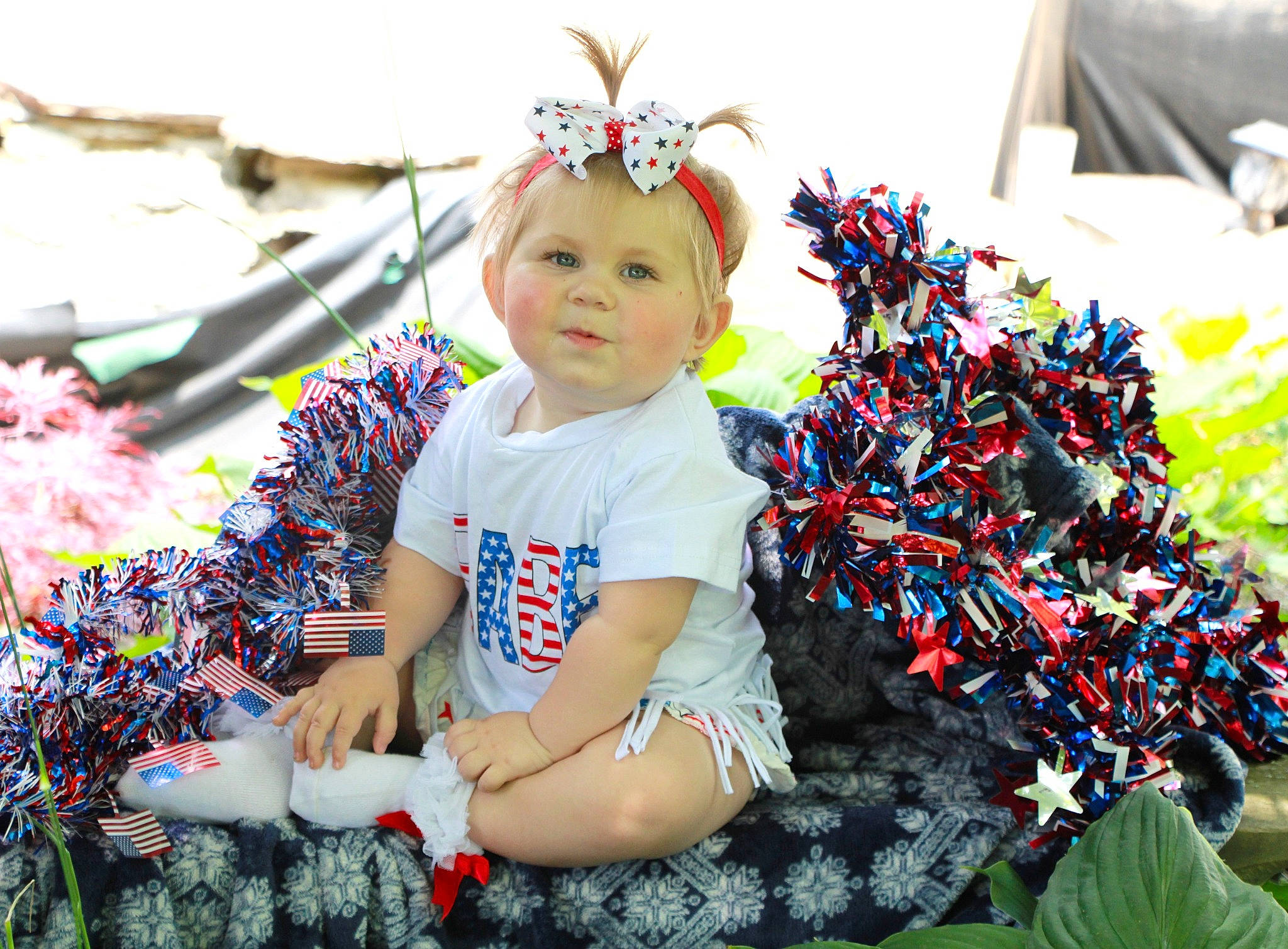 Annalise is registered to the contest to win money with this photo: baby, baby_toddler_clothing, child, event, eye, floral_design, fun, garden, grass, happy, headband, headwear, iris, pattern, people_in_nature, person, plant, portrait_photography, sitting, skin