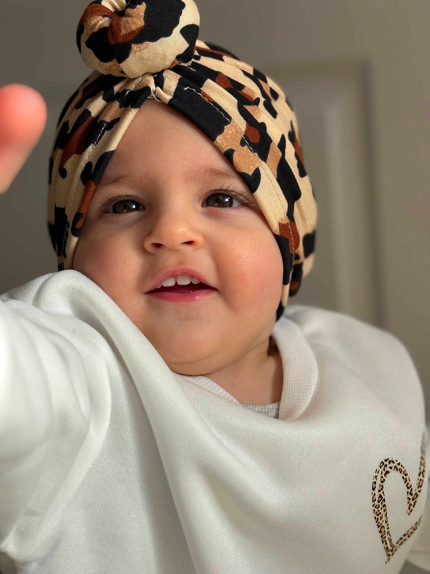 Giulia a rejoint le concours — aidez-le/la à gagner de superbes lots ! toddler, child, face, headwear, turban, leopard_print, white_sweater, heart_design, cute, smiling, portrait, indoor, baby, fashion, apparel, young_child, person, closeup, human, expression