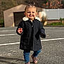 toddler, child, smiling, walking, coat, jacket, jeans, shoes, outdoor, street, pigtails, happy, daylight, asphalt, casual_clothing, person, cute, small_child, blurred_background, fashion