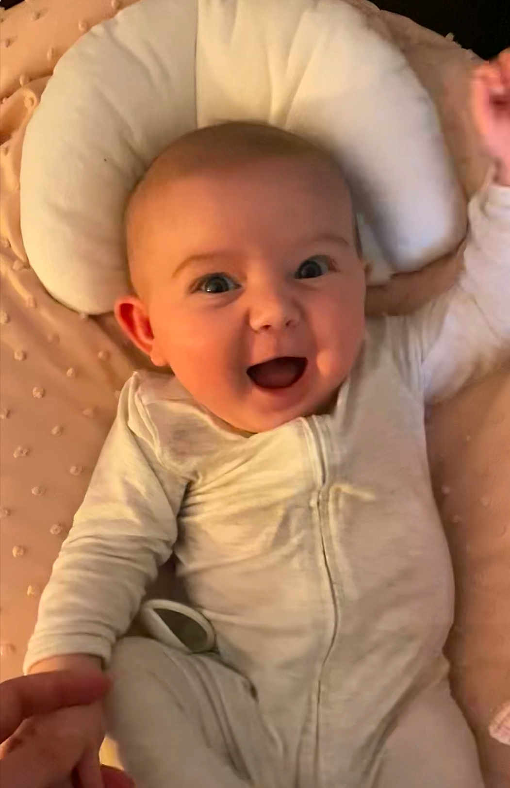Gemma joined the competition — help win amazing prizes! baby, infant, smiling, happy, onesie, lying_down, pillow, cushion, hand_holding, skin, face, cheerful, child, cute, indoors, expression, young, person, soft, comfort