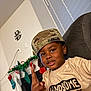 Harlem joined the competition — help win amazing prizes! child, boy, camouflage_cap, couch, christmas_stockings, garland, holiday, indoor, smiling, casual_pose, tshirt, wall, window_blinds, home_decor, person, furniture, portrait, happy, holiday_decoration, young
