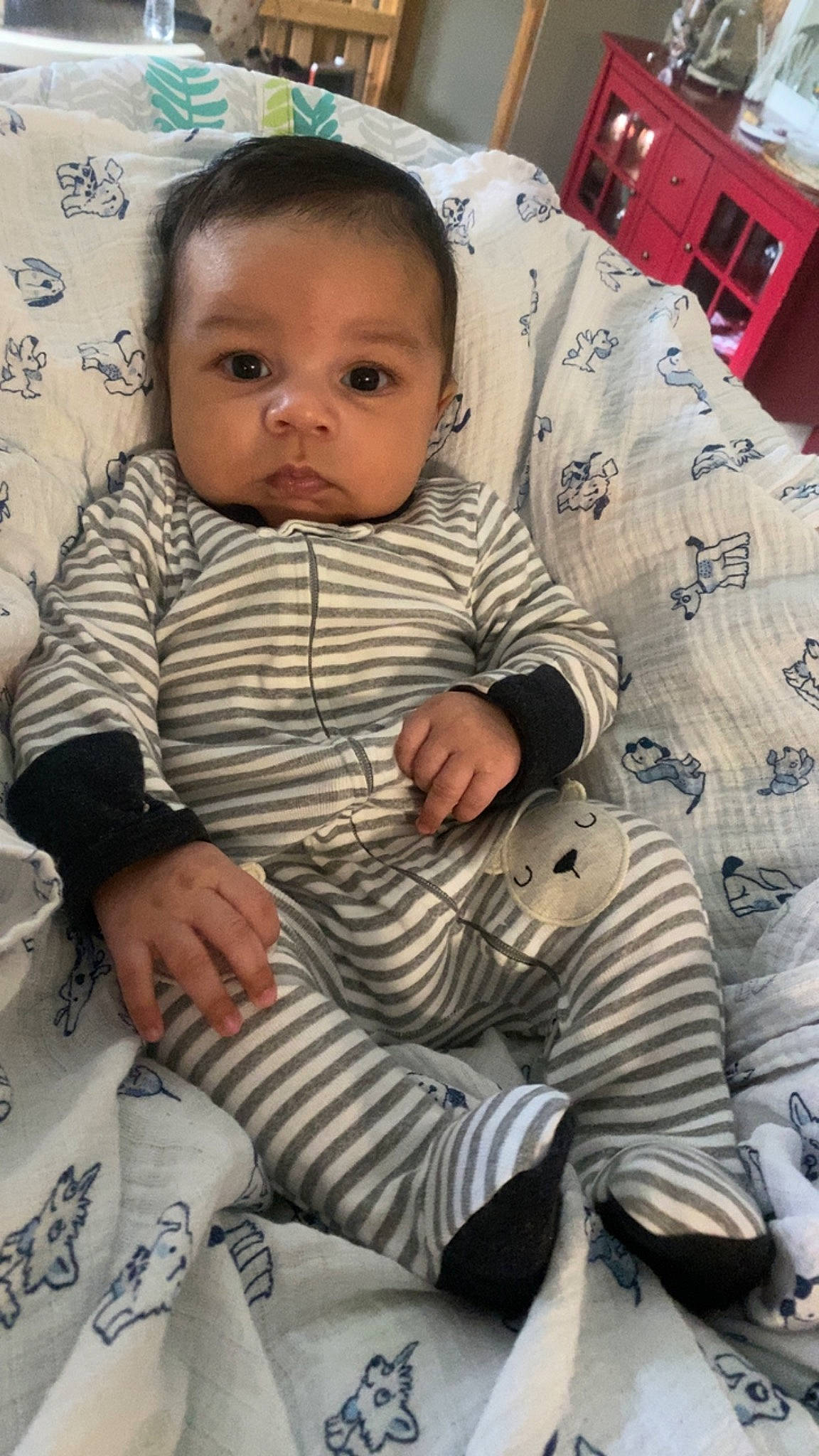 Devin is registered to the contest to win money with this photo: baby, baby_products, baby_toddler_clothing, cabinetry, cheek, child, comfort, cool, eye, finger, happy, head, lap, pattern, person, room, sitting, skin, sleeve, toddler