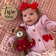 Brystol is registered to the contest to win money with this photo: baby, infant, two_months, milestone_card, headband, red_bow, pink_blanket, knit_sweater, cherries_pattern, plush_bear, toy, button, lying_down, portrait, cute, wide_eyes, soft_texture, toddler_clothes, sleepwear, prop