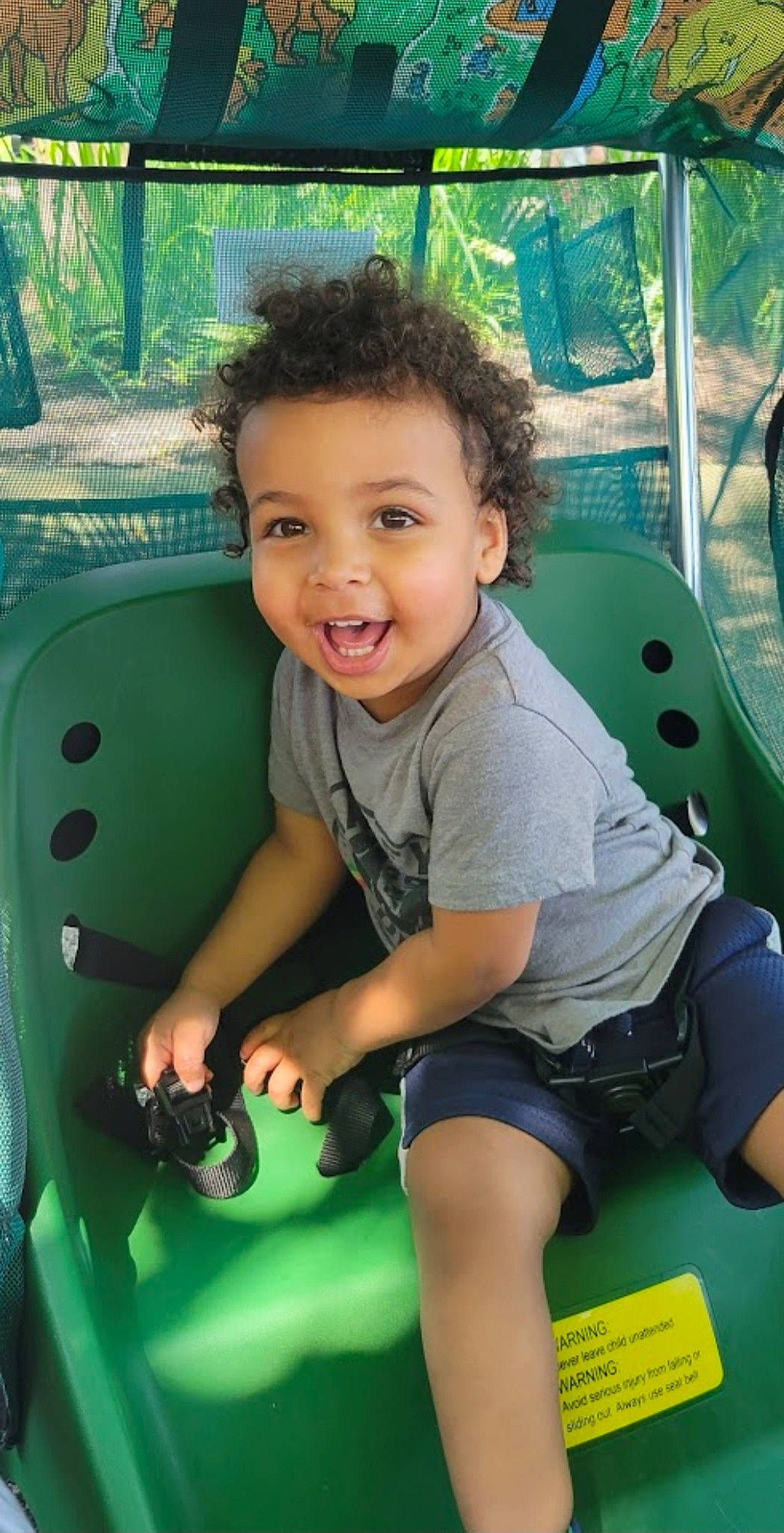 Garihs is registered to the contest to win money with this photo: automotive_tire, child, cool, eye, facial_expression, fun, grass, green, hairstyle, happy, joy, leisure, mammal, motor_vehicle, person, recreation, shorts, smile, t_shirt, toddler