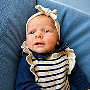Anouk participe au concours pour gagner de l'argent avec cette photo : baby, infant, headband, bow, striped_clothing, ruffles, blue_background, portrait, closeup, child, cute, young, apparel, person, face, skin, expression, sitting, indoors, soft_texture