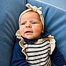 baby, infant, headband, bow, striped_clothing, ruffles, blue_background, portrait, closeup, child, cute, young, apparel, person, face, skin, expression, sitting, indoors, soft_texture