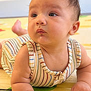 Dylan joined the competition — help win amazing prizes! baby, infant, child, tummy_time, portrait, face, eyes, hair, smiling, curious, indoor, play_mat, striped_clothing, romper, lying_down, hands, arms, colorful, close_up, photography
