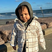 Adrian joined the competition — help win amazing prizes! toddler, child, hoodie, jacket, plaid, outdoor, beach, ocean, water, sky, clouds, rocks, sidewalk, casual, person, young_child, warm_clothing, daylight, nature, portrait