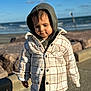 beach, casual, child, clouds, daylight, hoodie, jacket, nature, ocean, outdoor, person, plaid, portrait, rocks, sidewalk, sky, toddler, warm_clothing, water, young_child