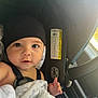 Adrian is registered to the contest to win money with this photo: baby, child, car_seat, blanket, beanie, infant, face, eyes, hand, safety_harness, interior, car, window, curious, cute, portrait, young, seatbelt, clothing, headwear
