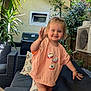 Lou a rejoint le concours — aidez-le/la à gagner de superbes lots ! toddler, child, smiling, waving, outdoor, sofa, cushion, patio, plant, greenery, grill, air_conditioner, window, shirt, shorts, daylight, happy, person, furniture, garden
