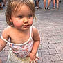toddler, child, outdoor, pavement, summer_clothing, blue_eyes, curly_hair, rosy_cheeks, people, legs, casual_wear, sandal, yellow_skirt, patterned_top, street, daylight, candid, portrait, cute, walking