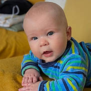 Tom a rejoint le concours — aidez-le/la à gagner de superbes lots ! baby, infant, child, blue_eyes, striped_clothing, sweater, hands, face, portrait, lying_down, blanket, mustard_color, soft_texture, indoor, cute, young, skin, expression, looking, closeup