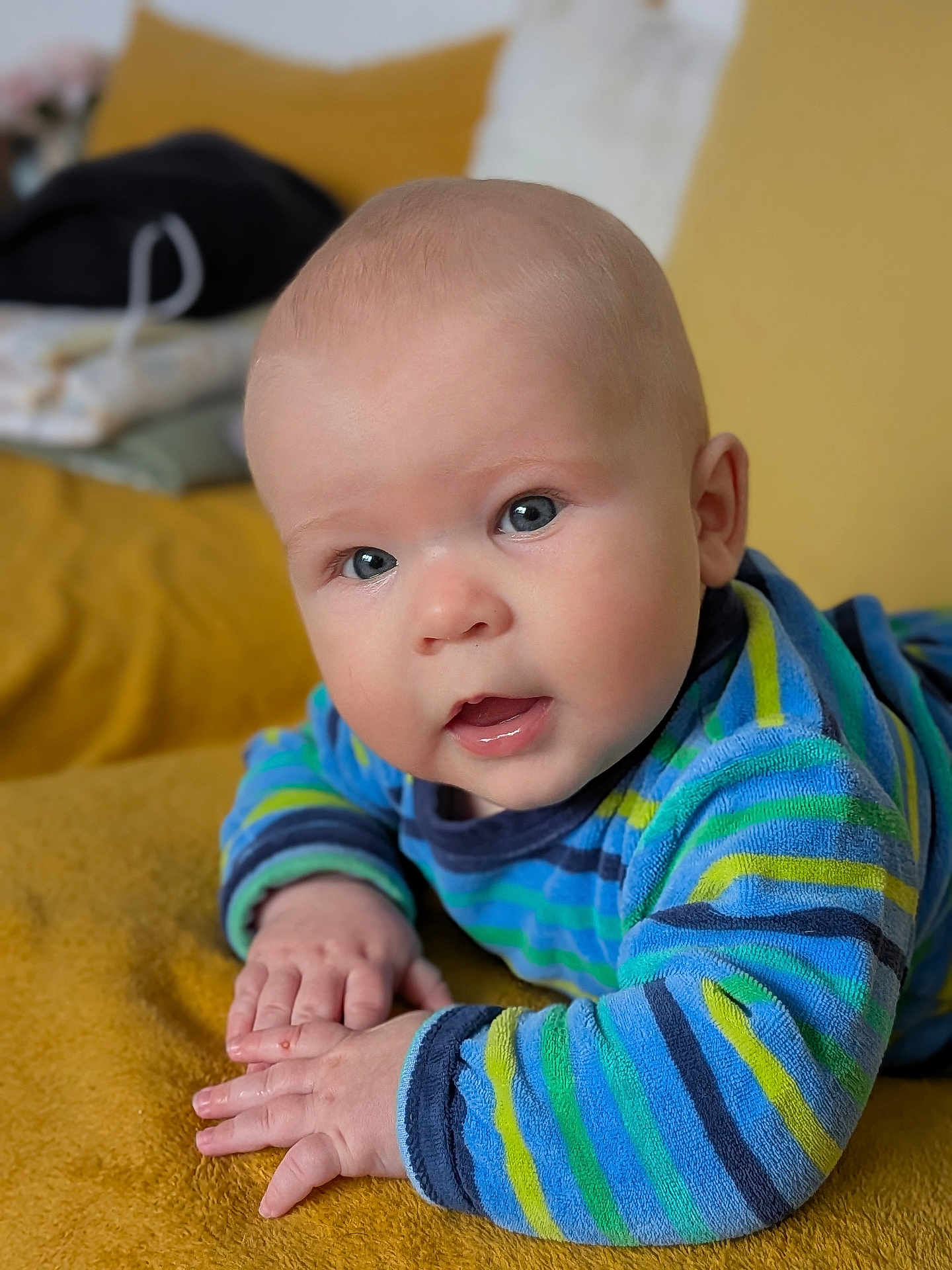 Tom a rejoint le concours — aidez-le/la à gagner de superbes lots ! baby, infant, child, blue_eyes, striped_clothing, sweater, hands, face, portrait, lying_down, blanket, mustard_color, soft_texture, indoor, cute, young, skin, expression, looking, closeup