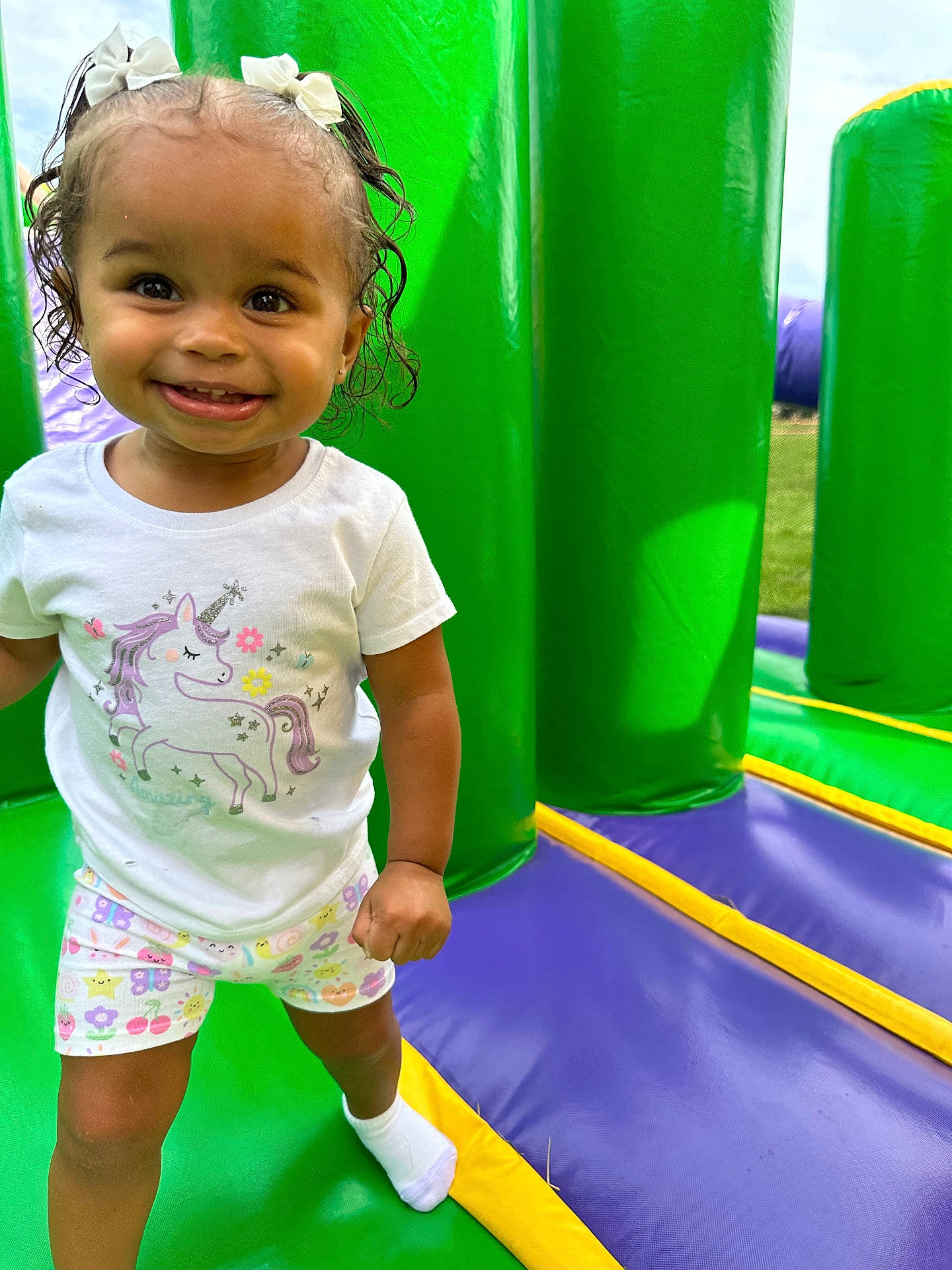 baby, clothing, face, grass, head, hosiery, indoors, inflatable, outdoorplayarea, outdoors, person, photography, plant, playarea, portrait, shorts, slide, sock, t_shirt, toy