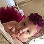 baby, infant, headband, purple, tutu, blanket, face, expression, indoors, child, cute, portrait, toddler, skin, hand, eyes, mouth, clothing, headwear, lying_down