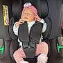 baby, newborn, car_seat, headband, pink_clothing, sleeping, infant, child, safety_harness, cozy, cute, soft_toys, legs, feet, white_sweater, indoor, blanket, resting, child_safety, adorable