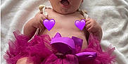 Zaïna a rejoint le concours — aidez-le/la à gagner de superbes lots ! baby, infant, purple_headband, purple_tutu, swing, wooden_swing, white_blanket, smiling, happy, cute, child, barefoot, toddler, playful, indoors, headwear, foot, person, portrait, funny