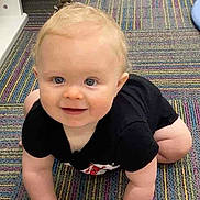 Creed Taylor is registered to the contest to win money with this photo: baby, black_onesie, blonde_hair, blue_eyes, carpet, child, colorful, crawling, cute, floor, hands, happy, indoor, infant, knees, person, plush, smile, striped, young_child