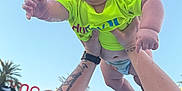 Creed Taylor joined the competition — help win amazing prizes! arms, baby, blue_sky, child, daylight, diaper, fun, happy, holding, joyful, neon_green, outdoor, palm_trees, person, playful, shirt, sky, smiling, tattoo, trees