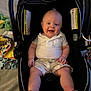 baby, blanket, car_seat, child, comfort, cute, face, footwear, happy, indoors, infant, person, sandals, seat, shorts, sitting, smiling, toy, white_shirt, young