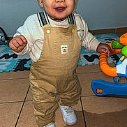 Elaïjah a rejoint le concours — aidez-le/la à gagner de superbes lots ! baby, child, clothing, face, floor, footwear, hand, happy, indoor, overalls, person, play, smile, sneakers, standing, tile, toddler, toy, walker, young