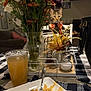 bouquet, bow_tie, cat, curious, decor, drink, flowers, food, fork, furniture, glass, indoor, kitchen, napkin, pasta, pet, plate, table, tablecloth, vase