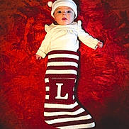 Lillian is registered to the contest to win money with this photo: baby, child, santa_hat, christmas_stocking, striped, red, white, knit, holiday, festive, cute, infant, lying_down, warm, cozy, face, headwear, christmas, seasonal, celebration